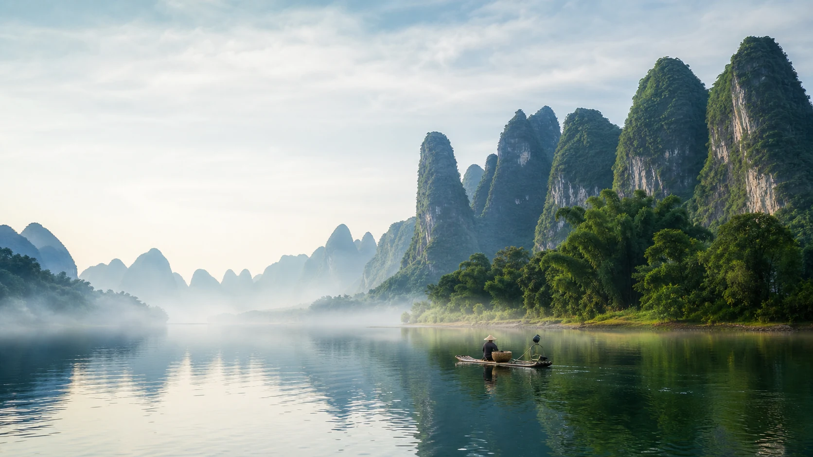 A bamboo raft on Guilin's Li River beneath misty karst peaks